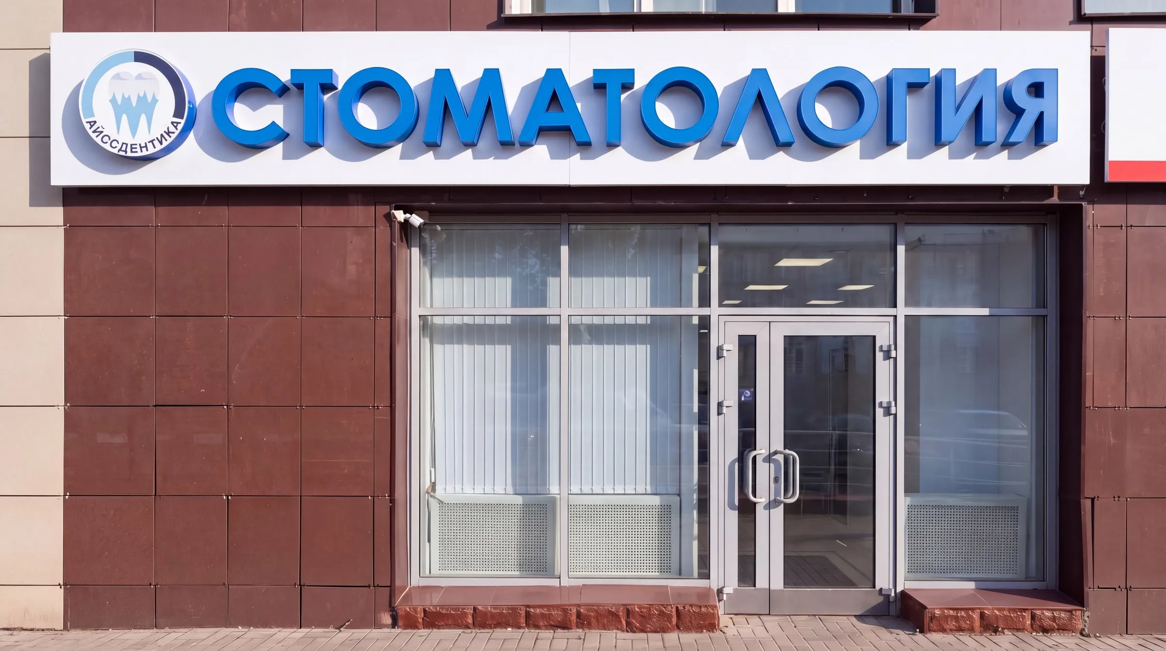 Вход в клинику «АйссДентика» на улице Тушинская: вывеска «Стоматология»